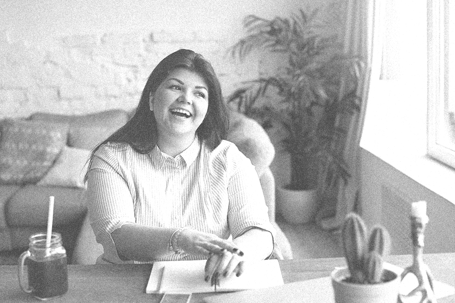 Candid photo of a woman speaking and talking at her desk.