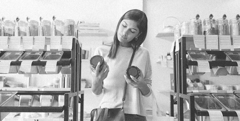 Woman comparing two glass jar labels.